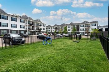 an apartment yard with a swing set in front of an apartment building